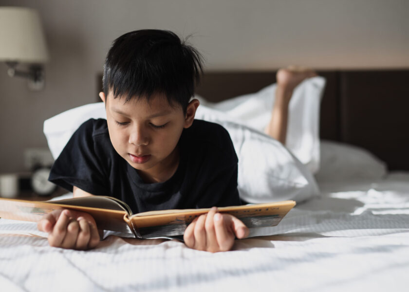 asian-boy-reading-a-book-on-bed-2021-09-04-03-08-12-utc